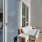 a sunlit balcony with a loveseat